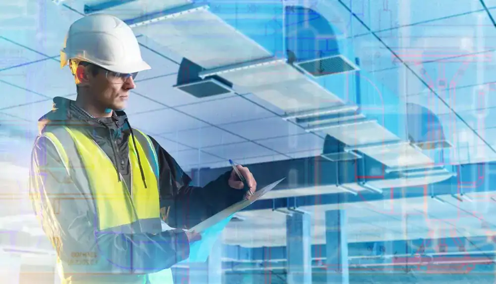 A construction worker wearing a hard hat and high-visibility vest inspects a building site indoors for an HVAC Contractor Nassau County, NY, holding a clipboard. HVAC ductwork and ceilings are visible in the background with a blue overlay effect.