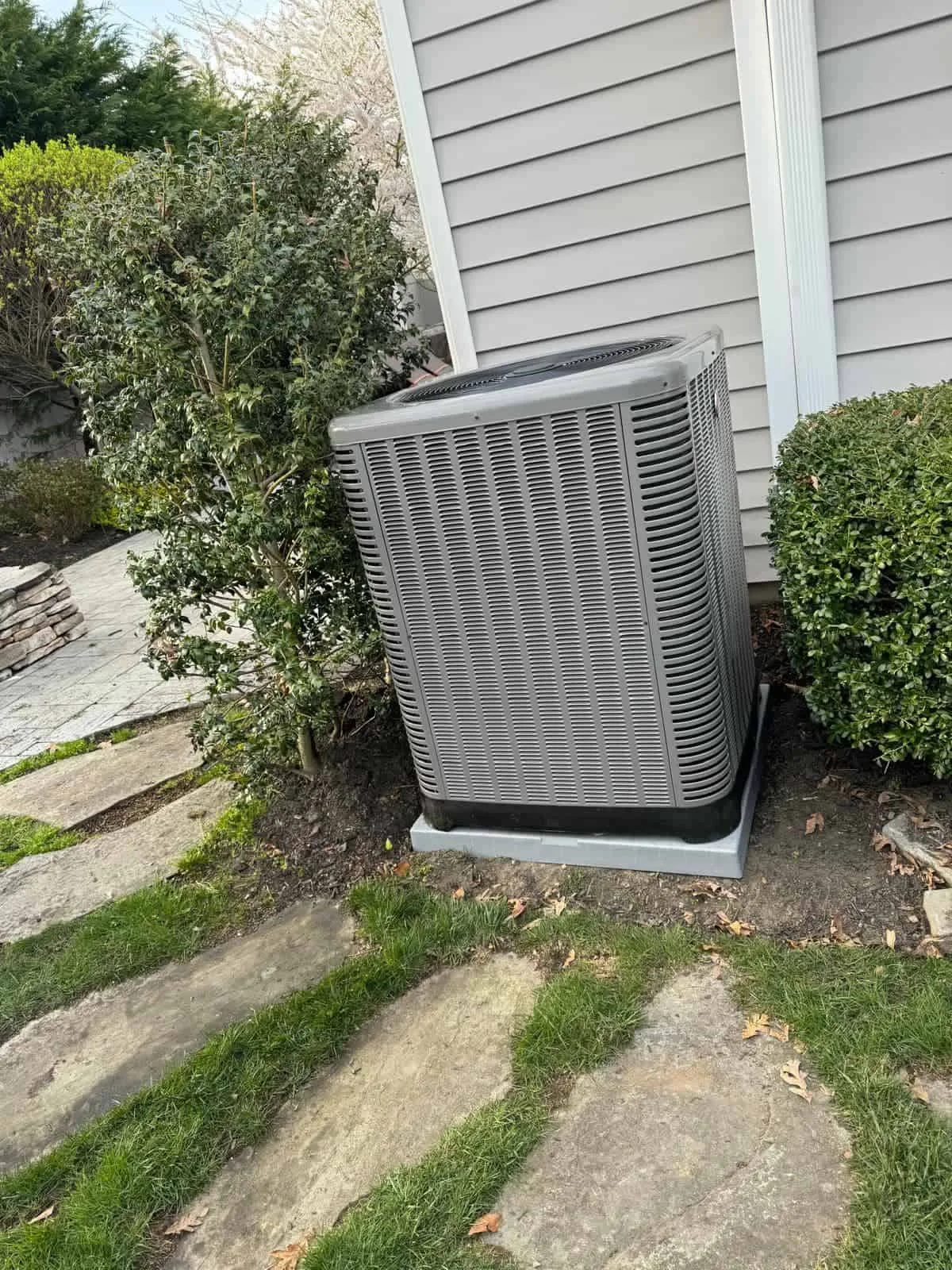 Residential outdoor HVAC unit installed beside a house.
