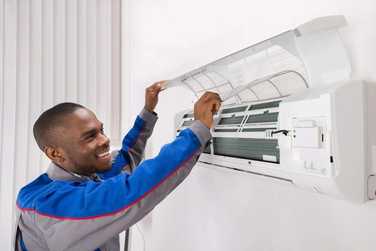 Technician servicing a wall-mounted air conditioner.