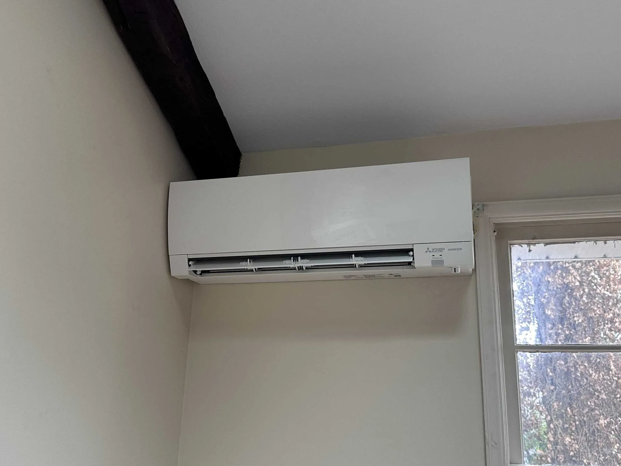 Wall mounted Mitsubishi air conditioner near a window